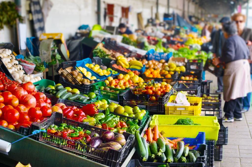 Colourful crates of fresh tomatoes, peppers, aubergines and fruit at a Portuguese outdoor market