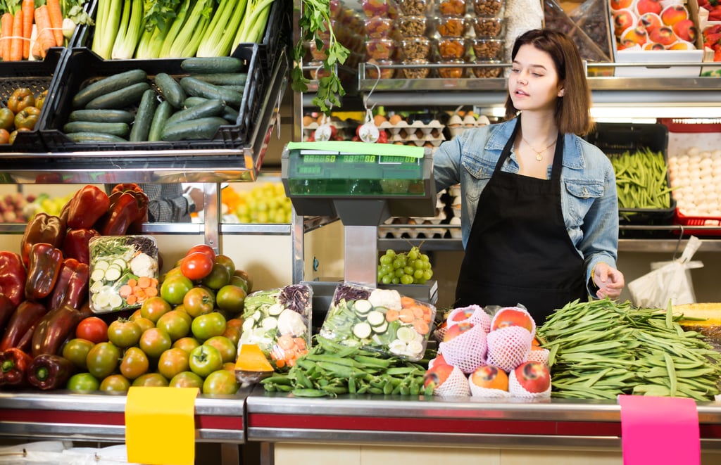 Supermarket worker weighing vegetables
