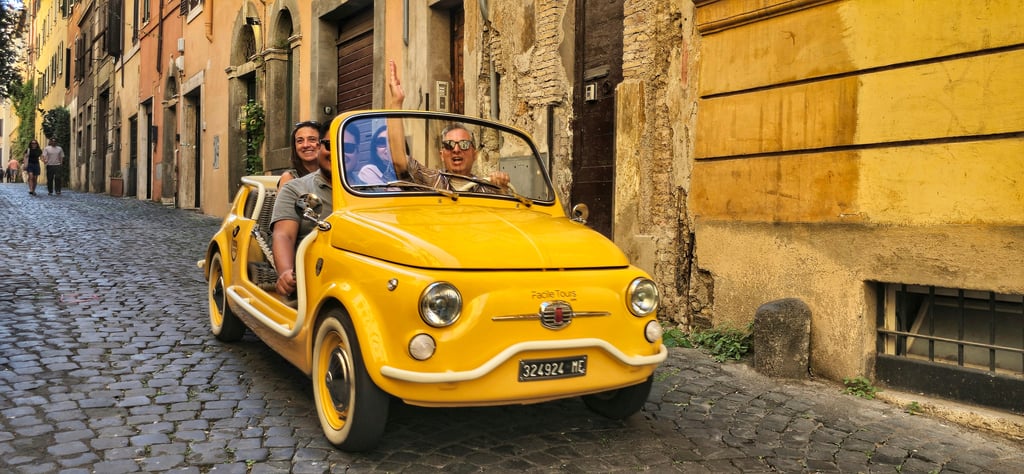 Yellow Fiat 500 on cobblestone street in Italy