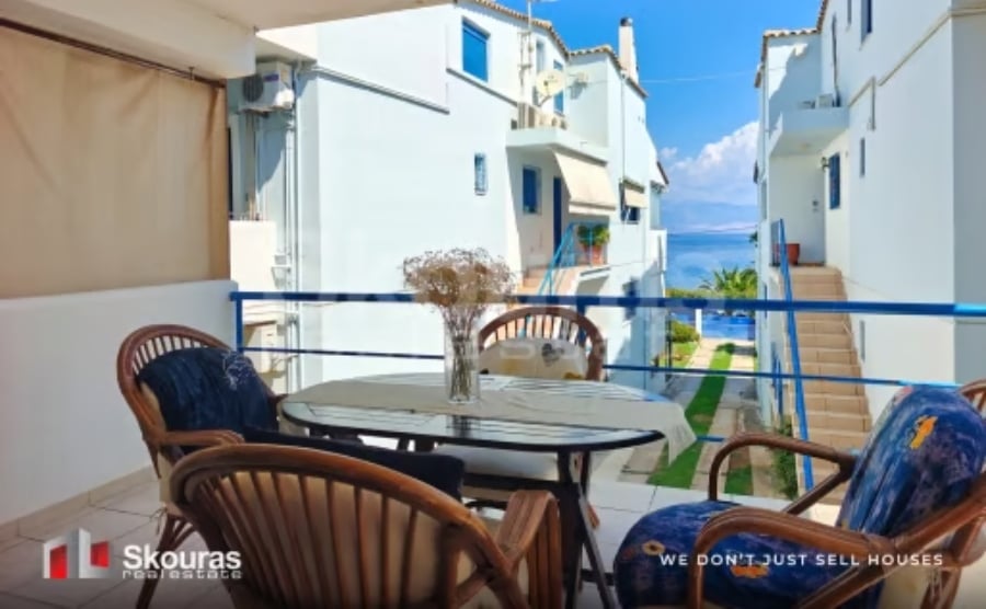 Affordable Greece property under €250,000 with a furnished terrace overlooking the sea between neighbouring homes.