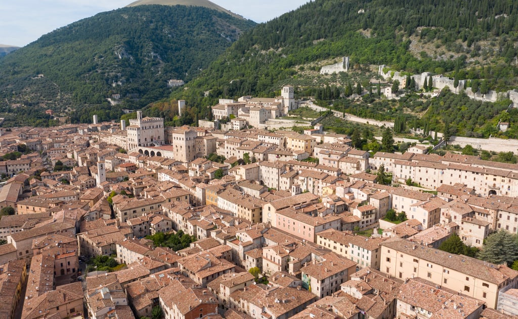 Umbrian hill town with tiled roofs, stone homes and green hills around Gubbio