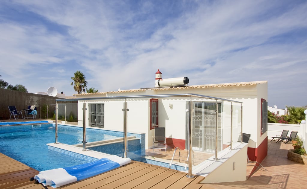 Modern villa with swimming pool for sale in the Algarve, Portugal, with terracotta roof tiles and landscaped garden
