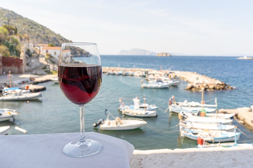 Red wine in front of Greek marina