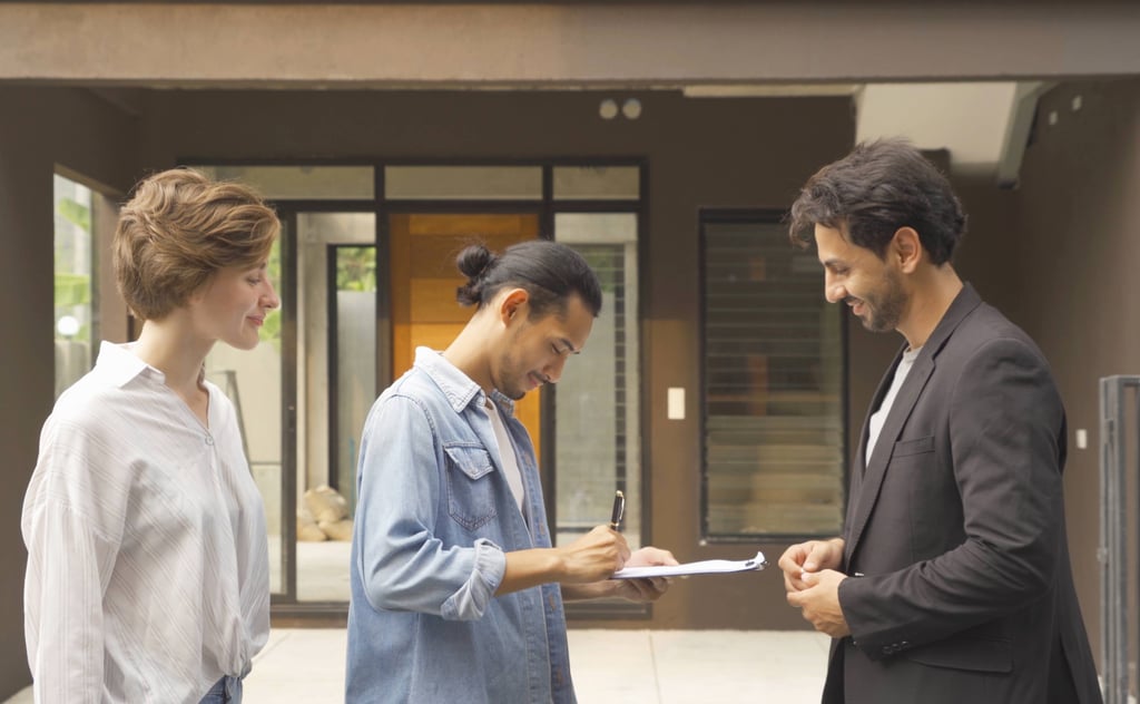 Buyers sign a property contract with an agent outside a home, a key stage when buying property in Portuga
