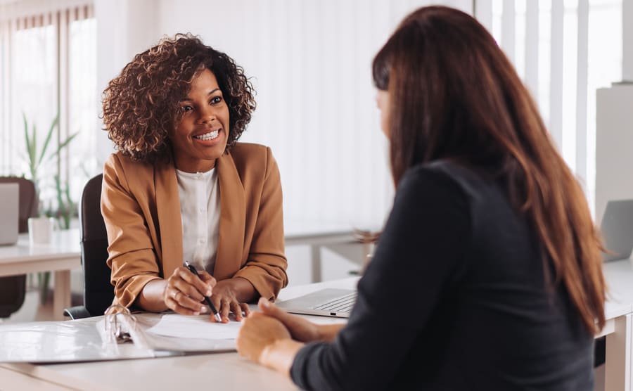 Two people in a bank discussing opening an account