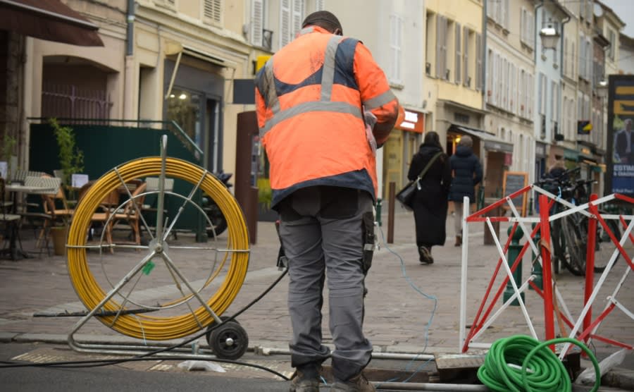 A technician installing fiber optic cable in France