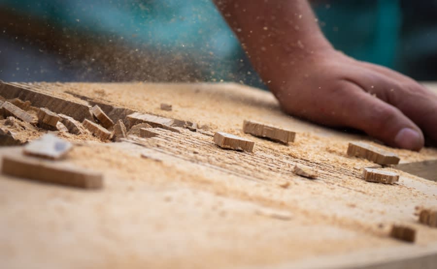 Action shot of carpenter hammering into wooden beam joint