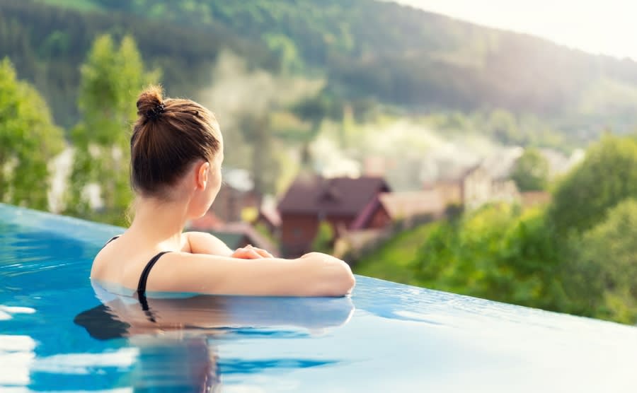 back view young adult female person enjoy relax in infinity edge