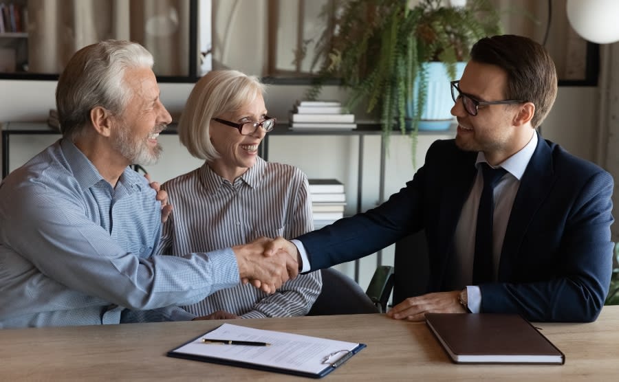 Couple shaking hands with mortgage broker