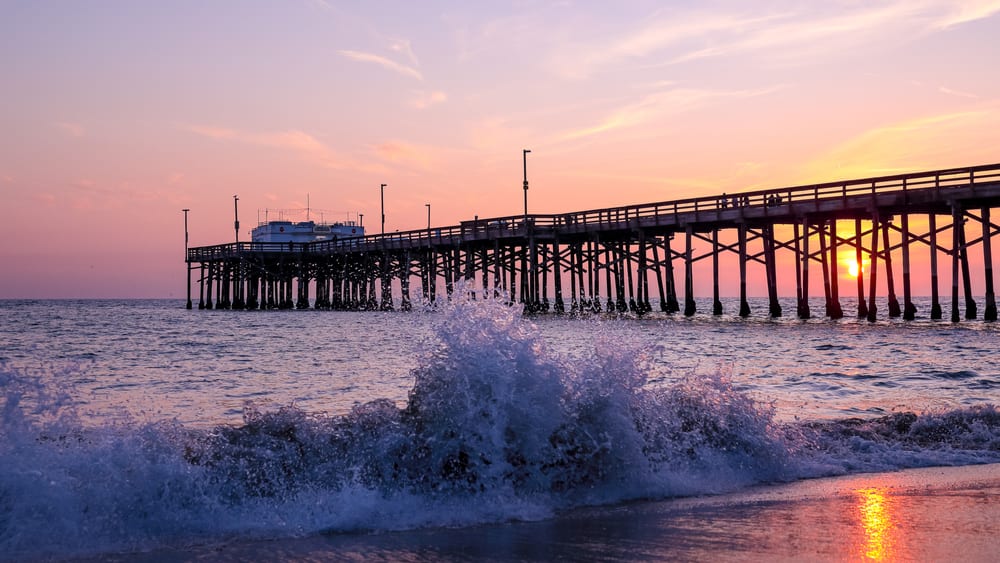 Scenic sunset over the Pacific ocean. A setting sun behind the long pier, Irvine, Orange County, California