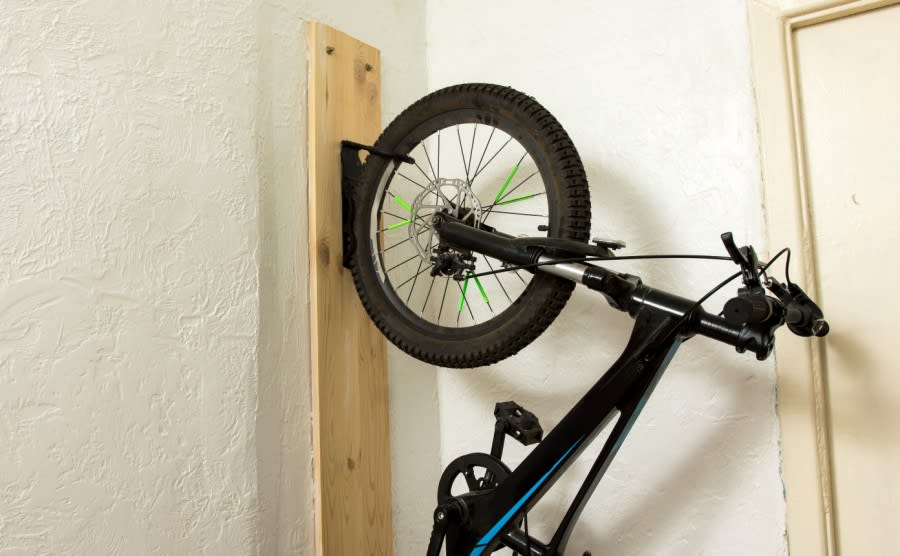 A mountain bike hanging from a wall mount in a holiday home