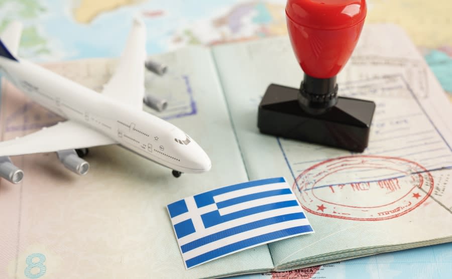 Greek flag on passport with toy plane and stamp