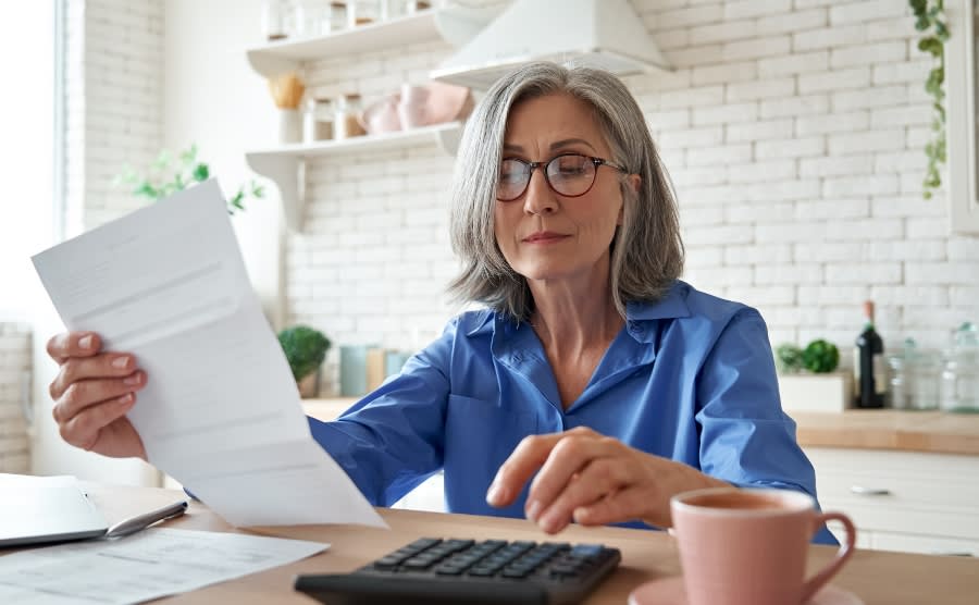Senior woman at kitchen table with tax bill