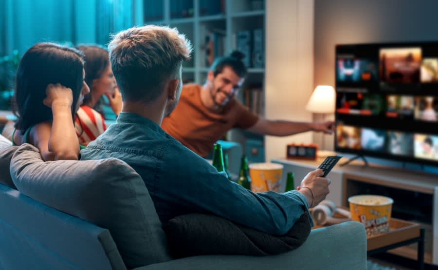 Friends choosing a movie to watch together at home, video on demand concept