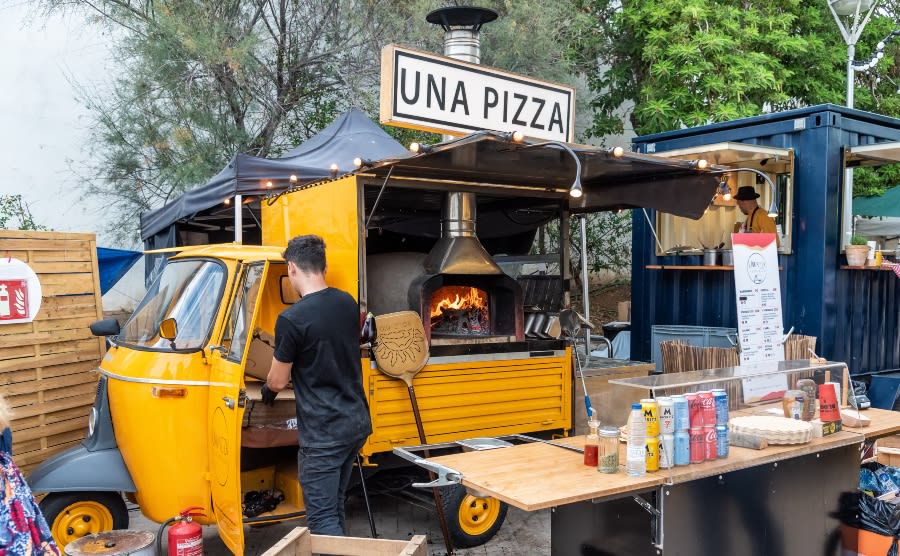 Man preparing pizzas to sell from a food truck