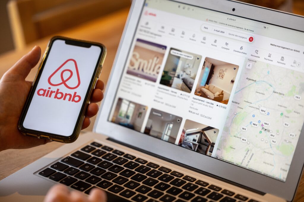 Airbnb open on a phone and laptop