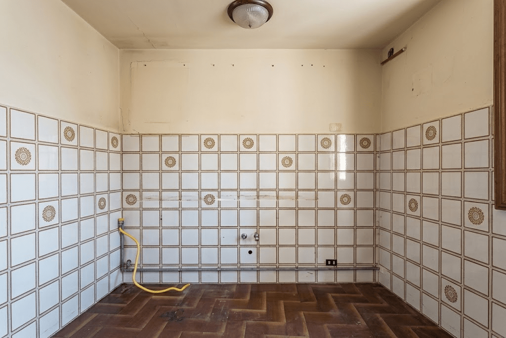 Kitchen before renovation, stripped back to old wall tiles